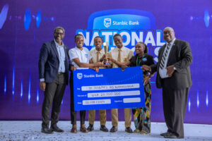 Sam Mwogeza, the Stanbic Bank Executive Director hands over a dummy cheque to St Josephs High School Namagunga who won in the Student Spark Category with their Sani Troll Project.