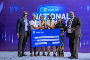 Sam Mwogeza, the Stanbic Bank Executive Director hands over a dummy cheque to St Josephs High School Namagunga who won in the Student Spark Category with their Sani Troll Project.
